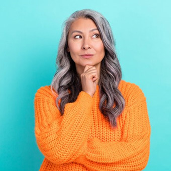 Woman in orange sweater looking concerned