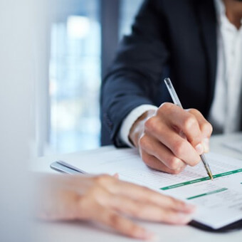 Close up of man with pen filling out a form