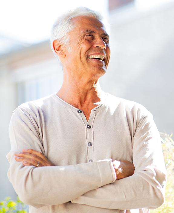 Man in white shirt smiling with arms folded