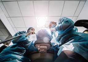 Dentists with masks surgically placing dental implants