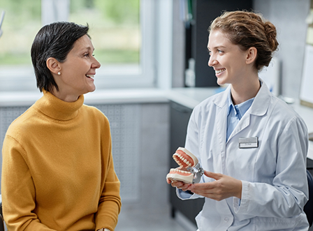 Woman in yellow shirt talking to female dentist