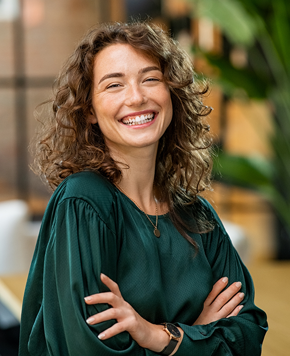 Woman in green shirt smiling with arms folded