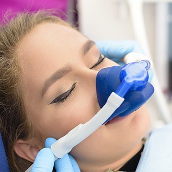 Woman in dental chair with nitrous oxide sedation mask over her nose